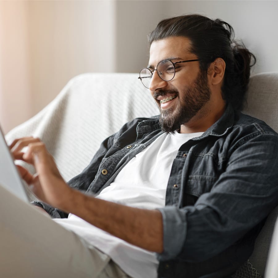 A man with braces is using a tablet.